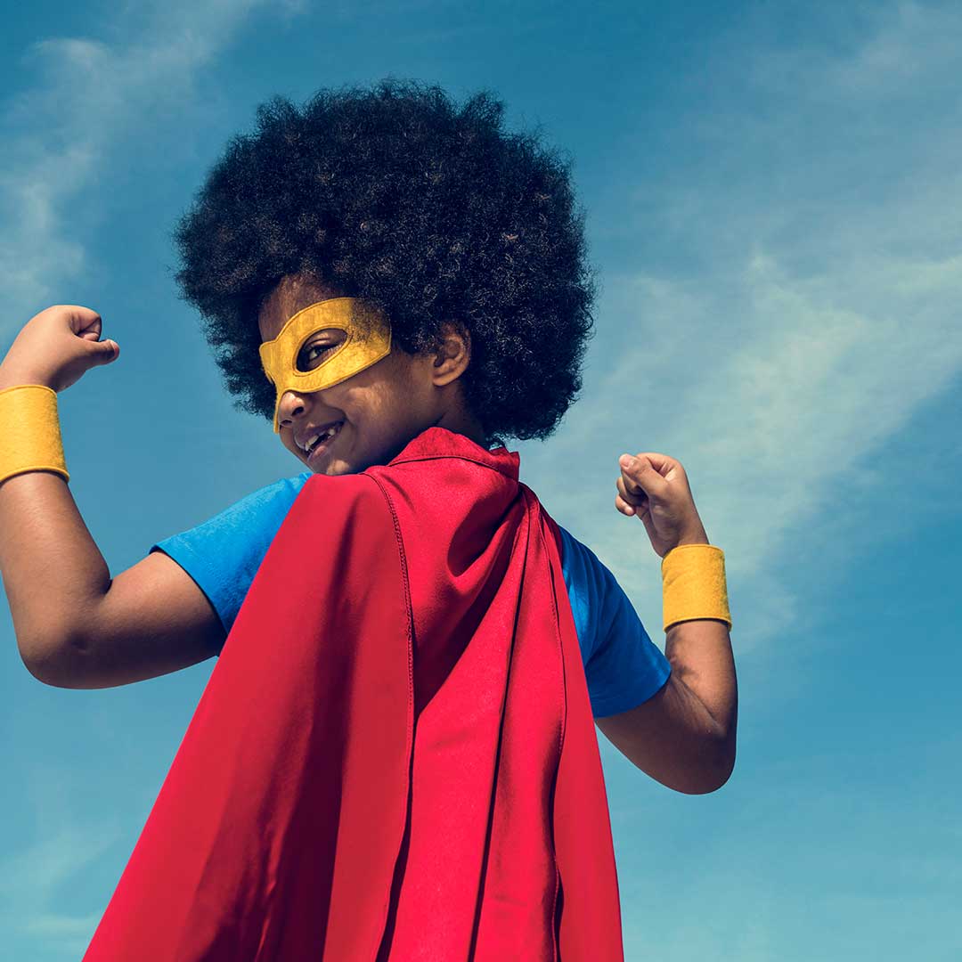 Kind mit Superman-Austattung lächelt